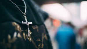 A woman wearing a necklace with a cross.