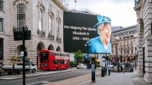 An electronic billboard stating "Her Majesty The Crown - Elizabeth II - 1926-2022
