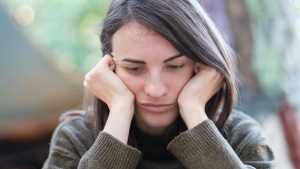 A woman resting her head on her hands.