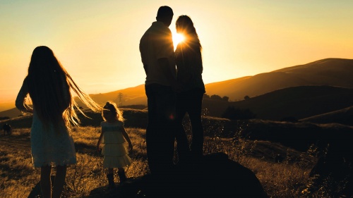 A family in a field at sunset.