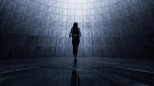 A woman surround by screens.