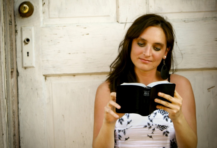 A young woman reading a Bible.