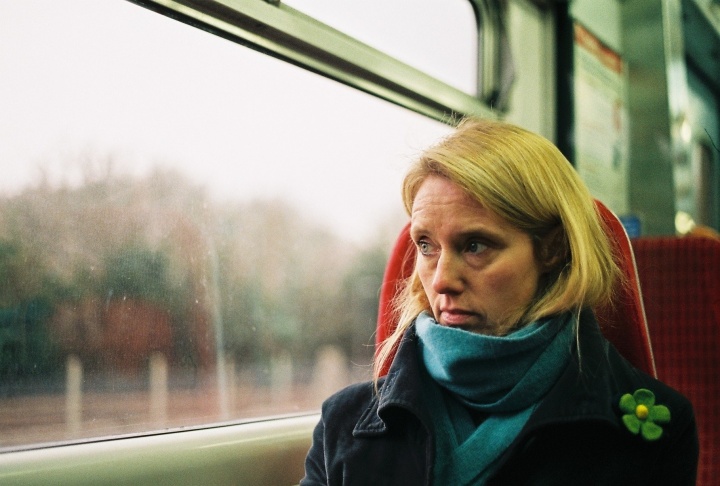 A woman sitting in a train looking out the window.