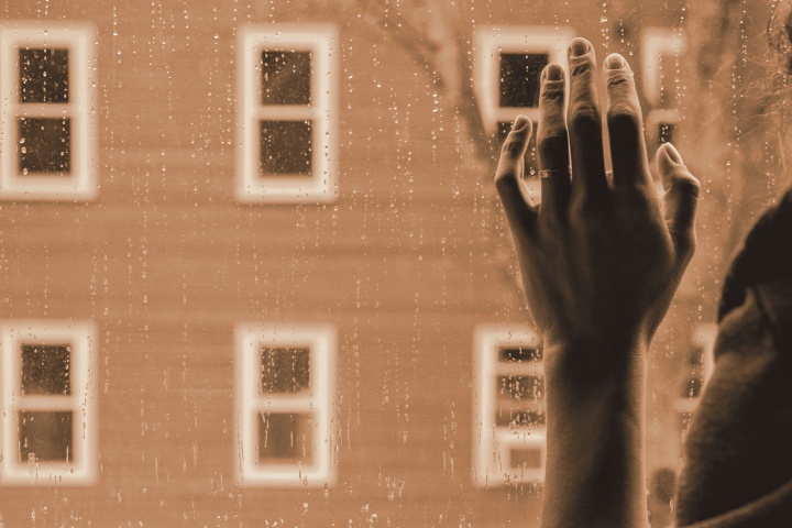 A woman hand against a window.