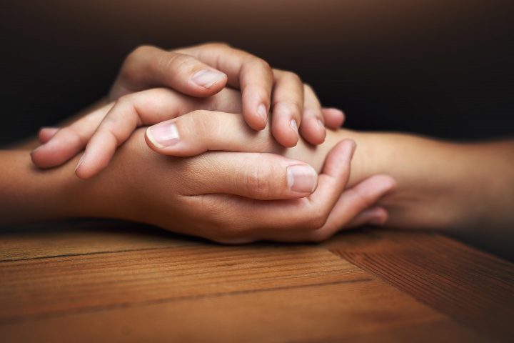 Two people's hands touching and showing comfort.