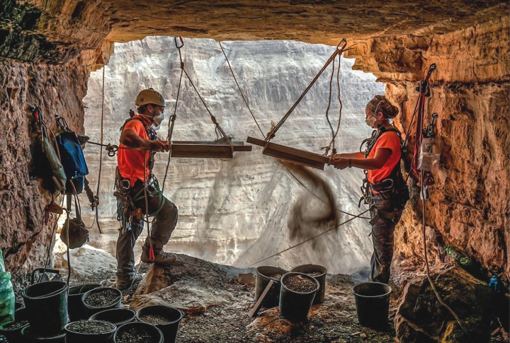 Israeli archeologists Hagay Hamer and Oriah Amichai sift dirt at a cave in the Judean Desert where addtional ancient scroll fragments were found.