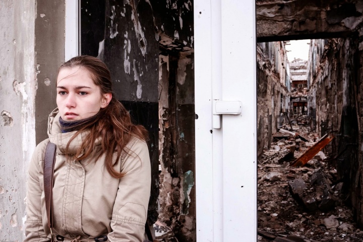 A young woman waits outside a building in Kurakhove, Eastern Ukraine.